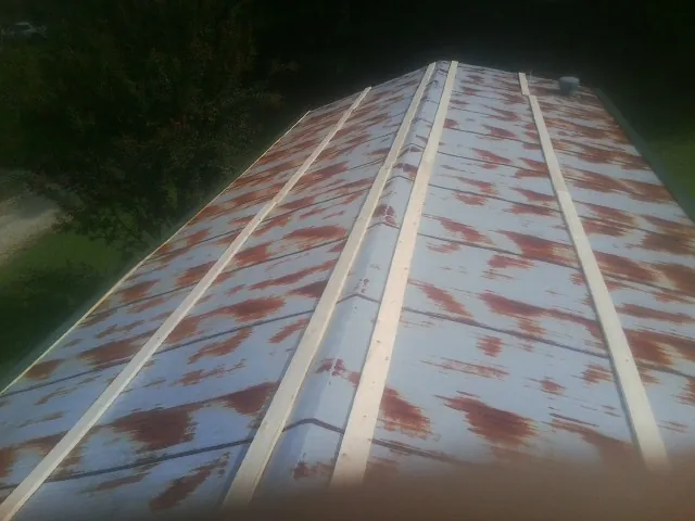 Rusted metal roof panels with new wood purlins before replacement — Storm Damage Roof Repair in Eaton by Roofing Brothers
