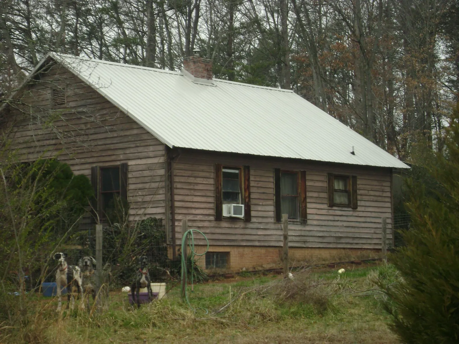 White metal roof on an old wood sided farmhouse, from a Metal Roof Installation job in Eaton